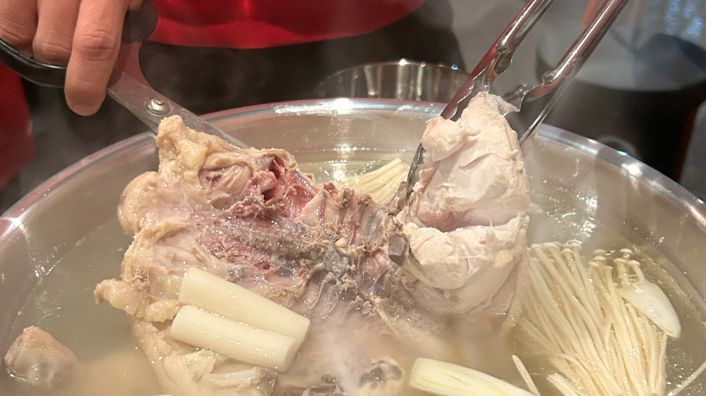 トングとハサミで鶏を切り分ける